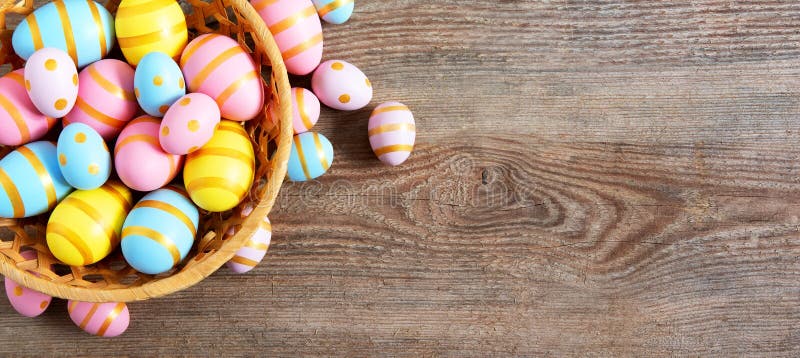 Happy Easter wooden background with pink, yellow and blue eggs