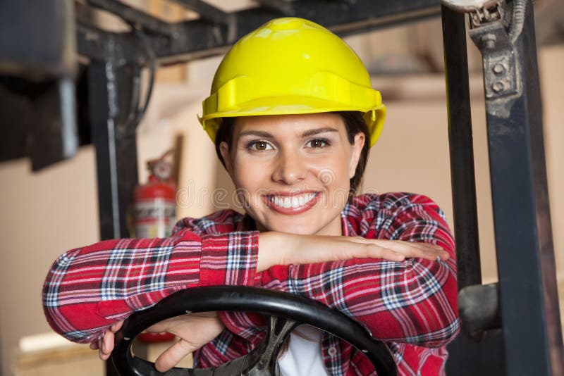 Happy Engineer Leaning On Forklift's Steering royalty free stock image