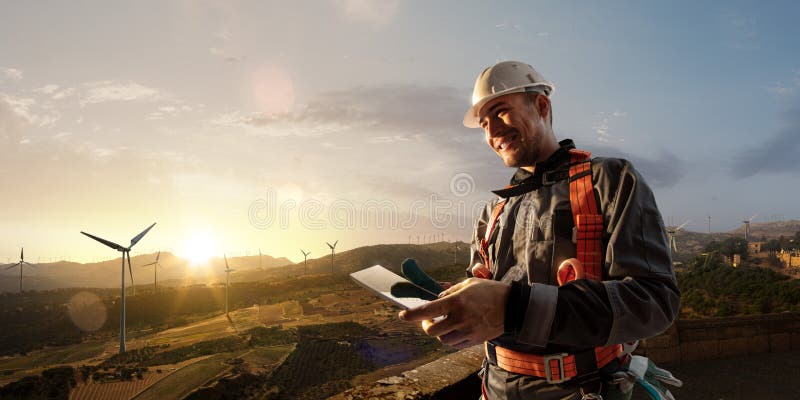 Happy engineer planning new project. He standing a top mount and looking in tablet royalty free stock image