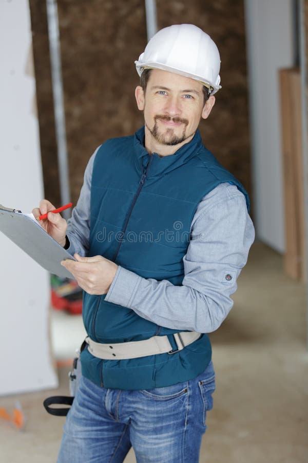 Happy engineer reviewing project plan on clipboard royalty free stock photo