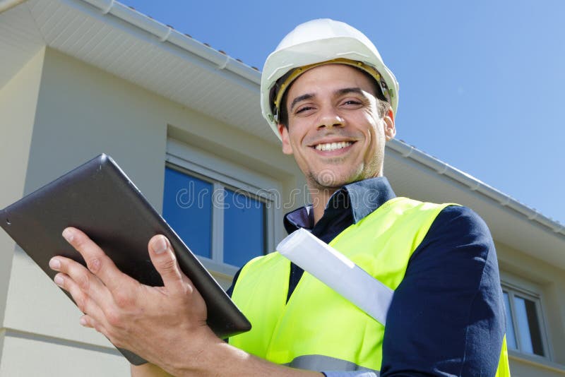 Happy engineer wearing vest outdoors stock images