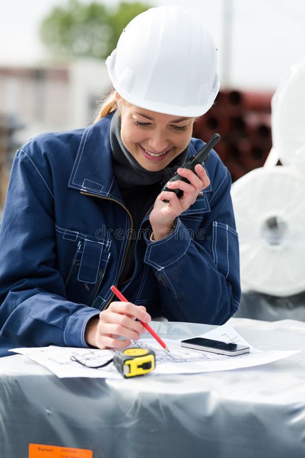 Happy engineer woman using radio communication outdoors royalty free stock photo