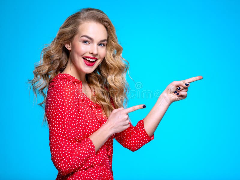 Happy excited caucasian woman points on the palm. Young blonde woman with positive emotions.  Beautiful expressive girl is