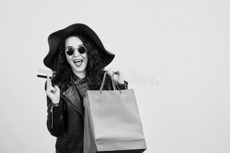 Happy excited hipster woman in sunglasses holding credit card and colorful shopping bags. ?heerful woman looking at camera, isolat stock images Happy excited hipster woman in sunglasses holding credit card and colorful shopping bags. ?heerful woman looking at camera, isolat stock images