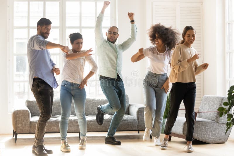 Overjoyed multiracial young people dancing together indoors