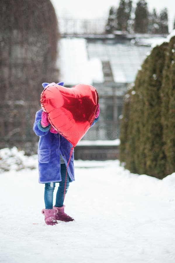 Happy exited girl with Valentine heart balloons outdoor. Valentine`s day concept. Copy space. royalty free stock image Happy exited girl with Valentine heart balloons outdoor. Valentine`s day concept. Copy space. royalty free stock image