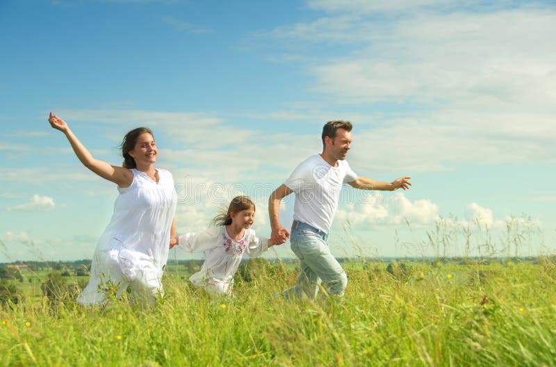 Familia feliz correr sobre el prado.