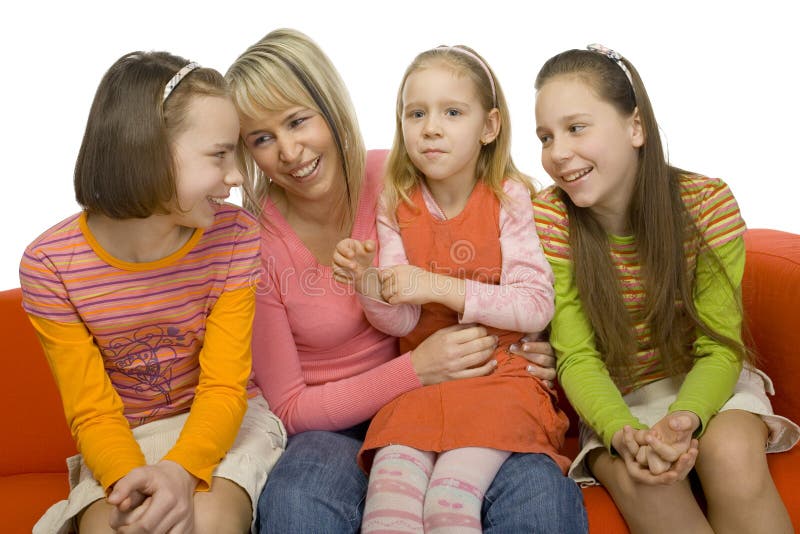 There're 3 girls and their mother sitting on the orange couch. They're having good time. There're 3 girls and their mother sitting on the orange couch. They're having good time.