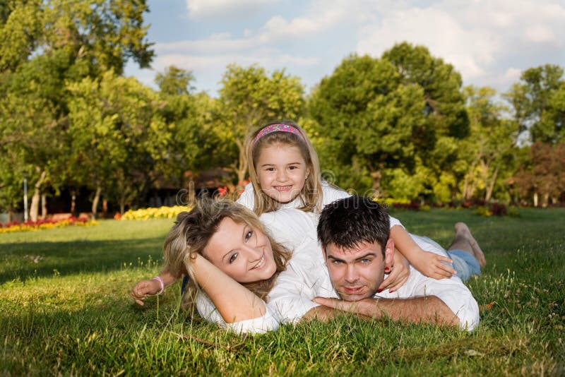 Daugnter, mother and father playing outside on a sunny day. Happy embracing couple stock images, royalty-free photos and pictures