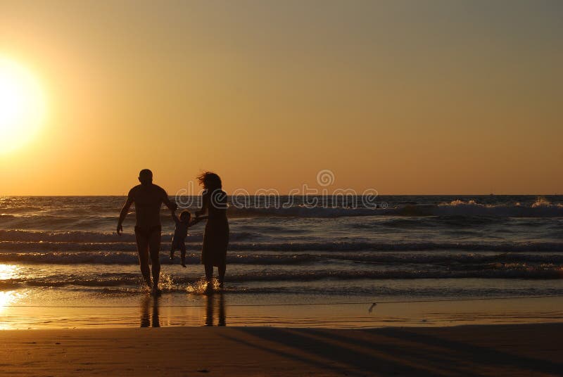 Glückliche Familie auf dem Meer Strand im moment des Sonnenuntergangs.