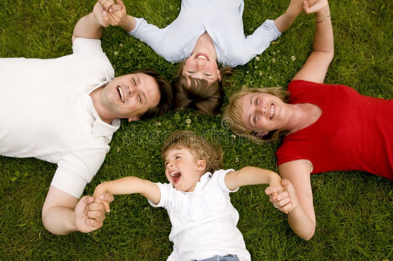 Happy family. Parents with kids laying on the grass Happy family. Parents with kids laying on the grass