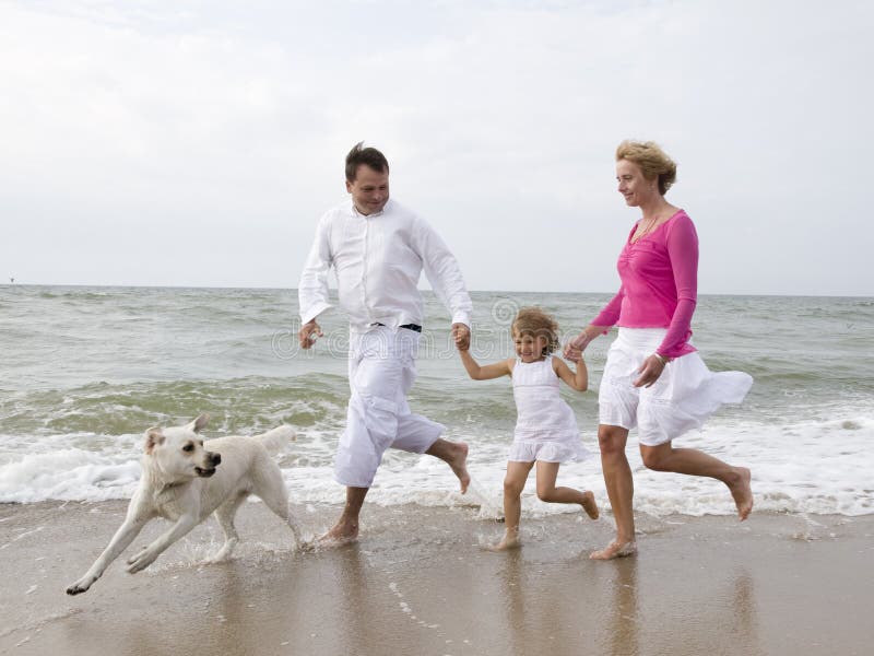 Gestione familiare con labrador retriever sulla spiaggia.