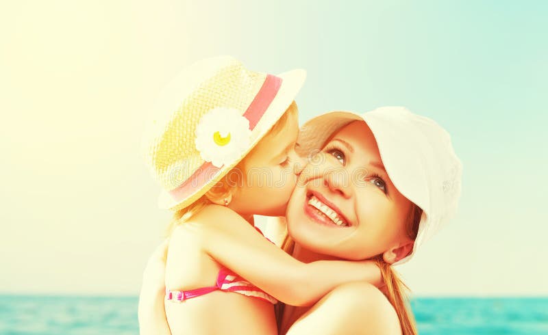 Happy family on beach. baby daughter kissing mother