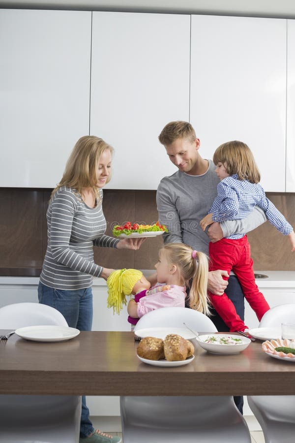 Happy family with children having meal in domestic kitchen stock photos Happy family with children having meal in domestic kitchen stock photos