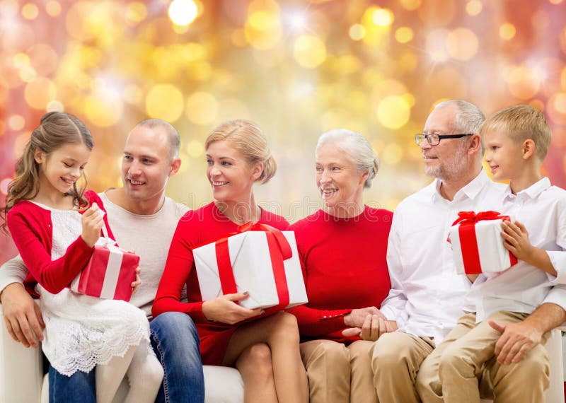 Happy family with christmas gifts over lights. Elderly, aged.