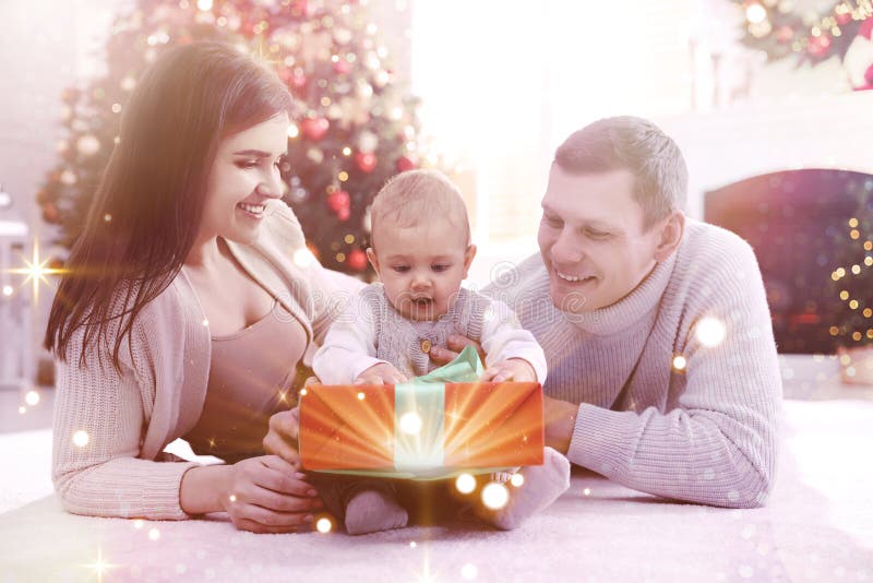 Happy family with cute baby on floor in room decorated for Christmas. Magical festive atmosphere royalty free stock images