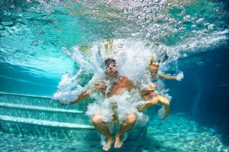 Happy family diving underwater with fun in swimming pool stock image