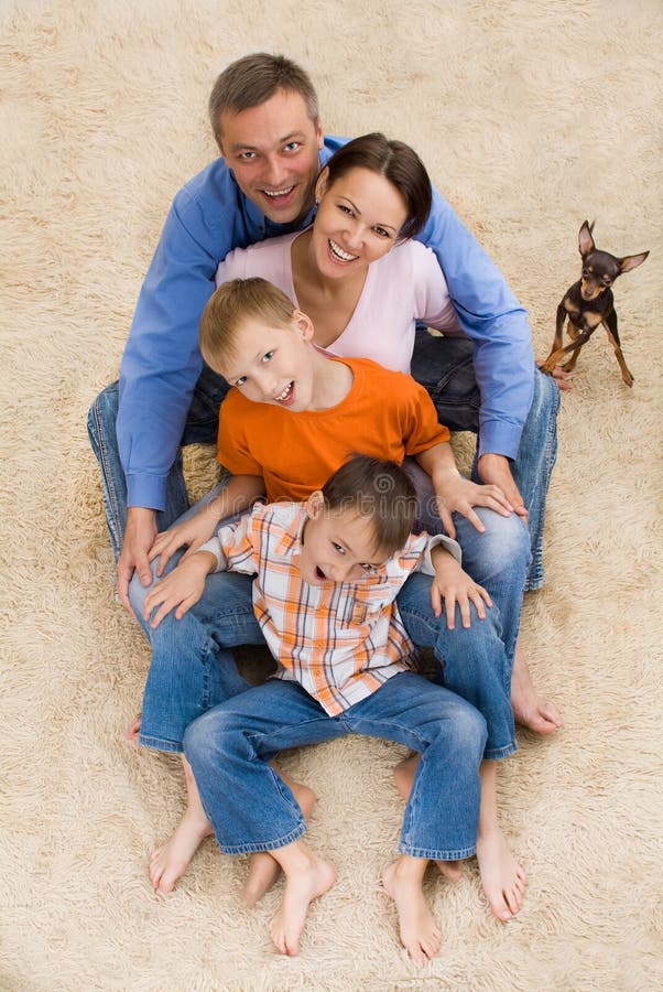 Happy family and dog on the carpet