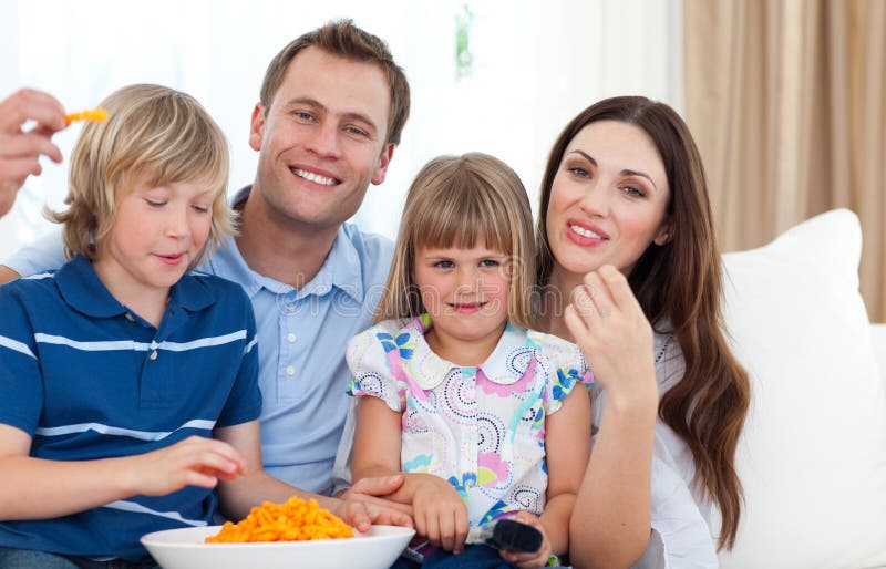 Happy family eating crisps