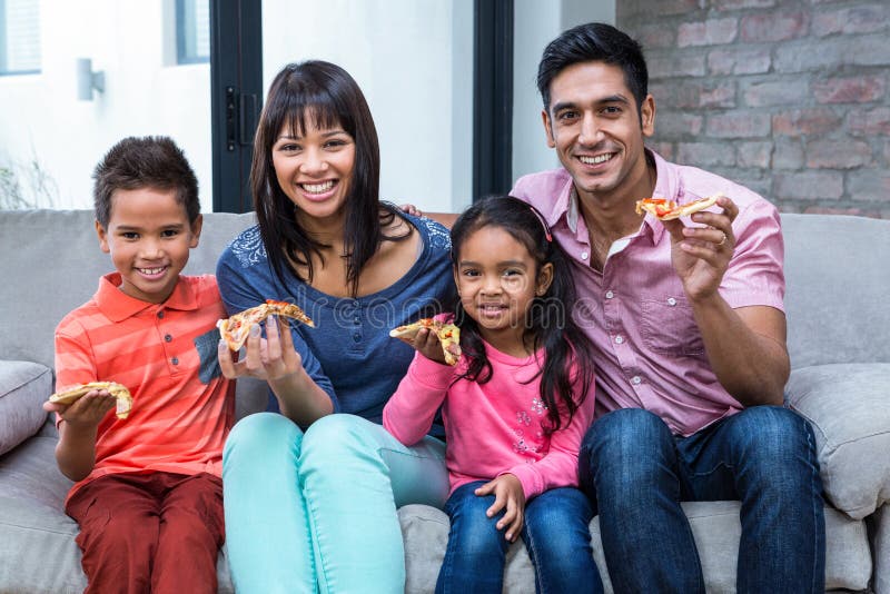 Happy family eating pizza on the sofa stock images Happy family eating pizza on the sofa stock images