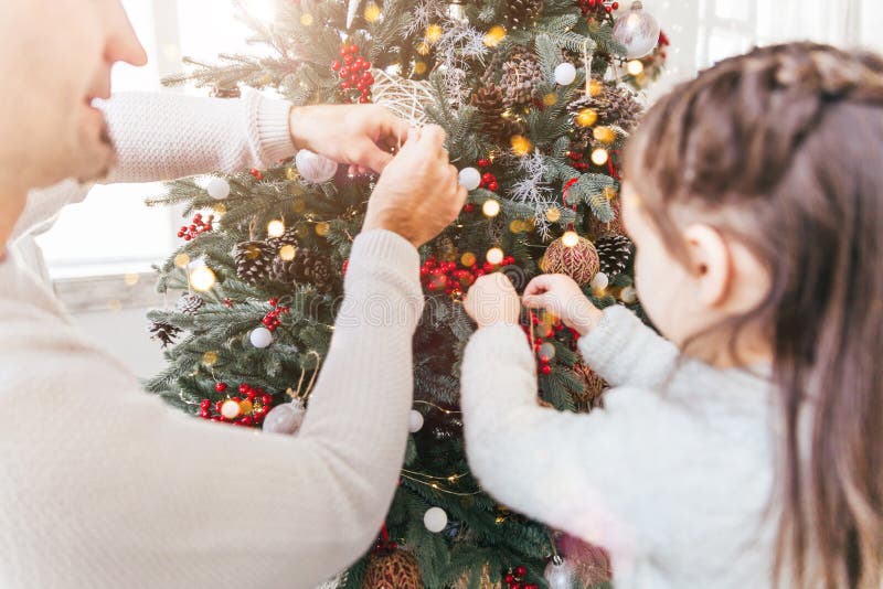 Happy family: father and daughter decorating Christmas tree