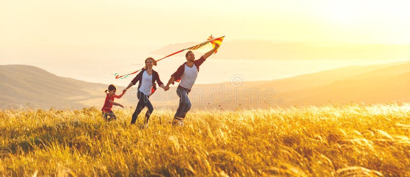 Happy family father, mother and child daughter launch a kite on stock photos Happy family father, mother and child daughter launch a kite on stock photos