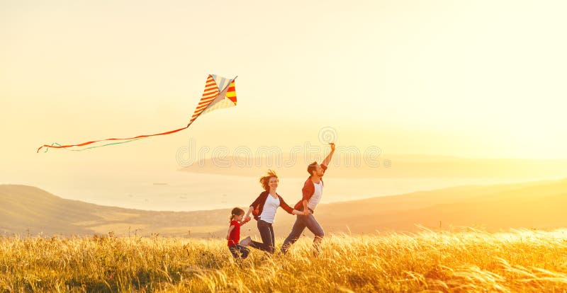 Happy family father of mother and child daughter launch a kite o stock photo Happy family father of mother and child daughter launch a kite o stock photo