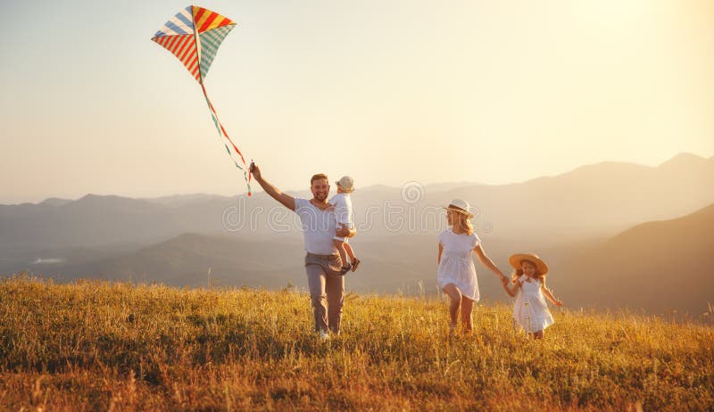 Happy family father, mother and children launch kite on nature