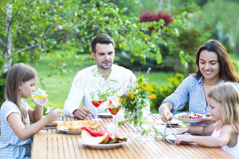 Happy Family of Four People Enjoying Meal Together Outdoors Stock Image