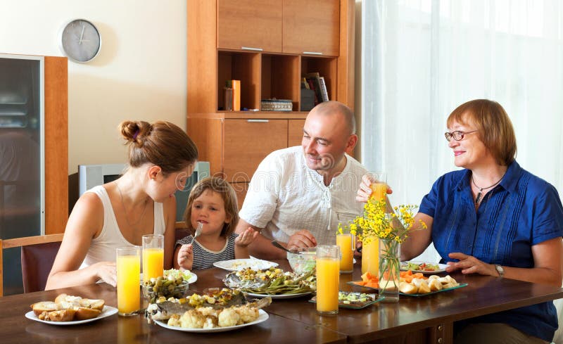 Happy family having healthy dinner with fish at home together stock images Happy family having healthy dinner with fish at home together stock images