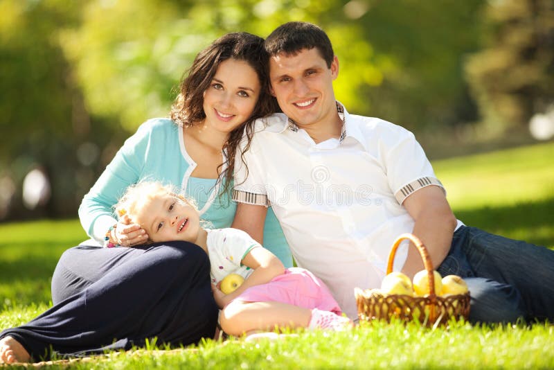 Happy family having a picnic in the green garden