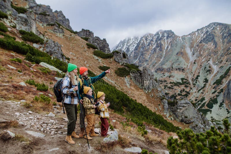 Šťastná rodinná turistika společně v podzimních horách.