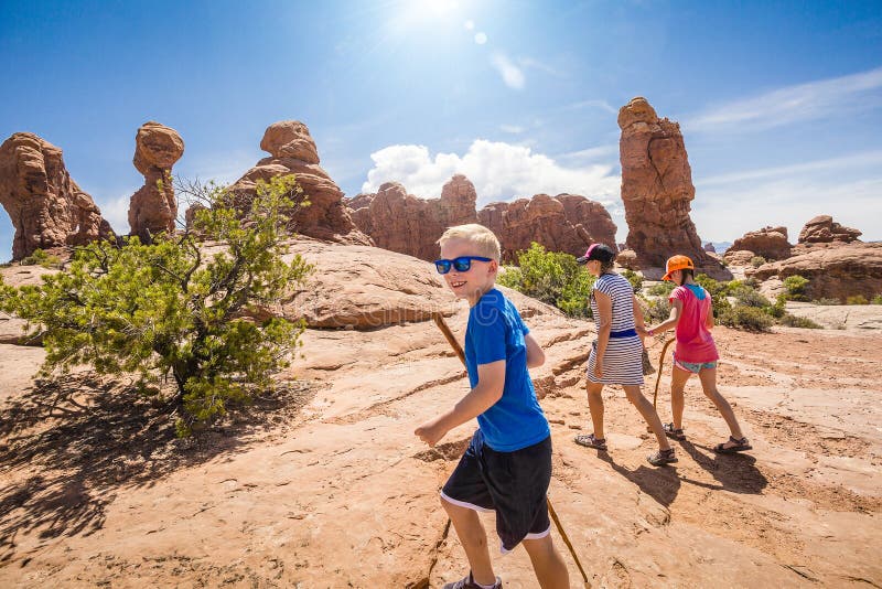 Happy family hiking together in the beautiful rock formations of Arches National Park