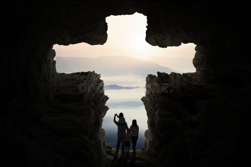 Happy family inside cave shaped cross sign stock photography Happy family inside cave shaped cross sign stock photography