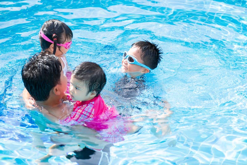Happy family with kids having fun in swimming pool. stock photo Happy family with kids having fun in swimming pool. stock photo