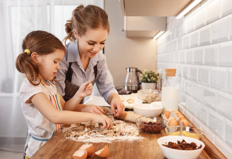 Happy family in kitchen. mother and child daughter baking cookies. Together stock photo