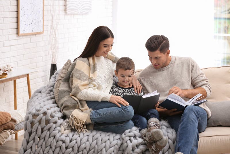 Happy family with little son reading books. Winter vacation