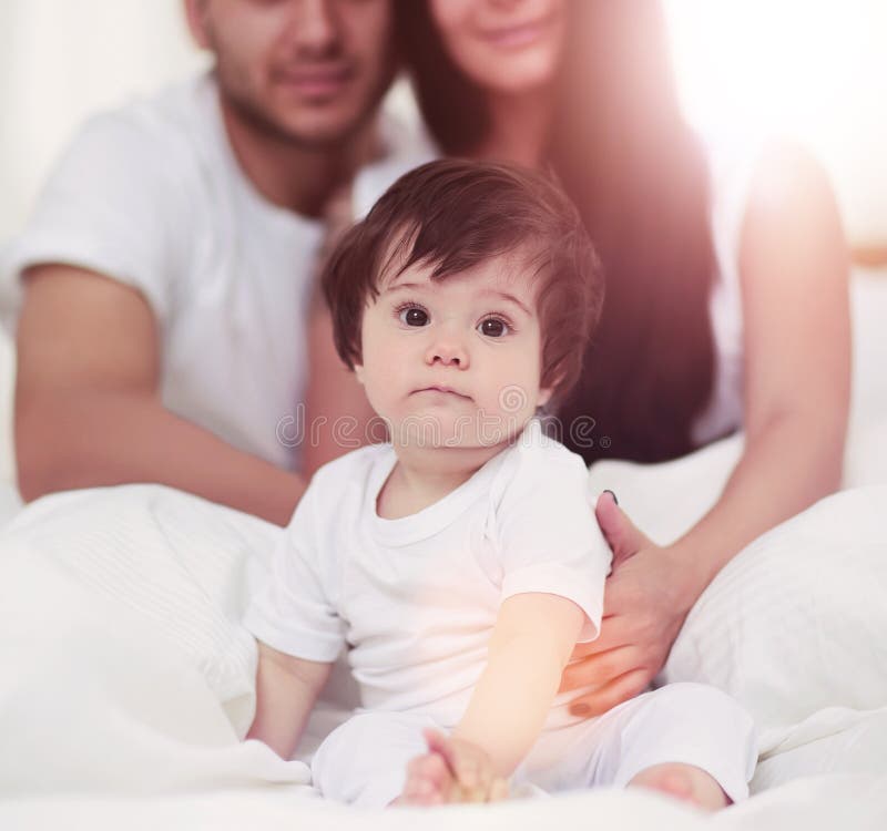 Portrait of a joyful family sitting on the bed at home royalty free stock photo Portrait of a joyful family sitting on the bed at home royalty free stock photo