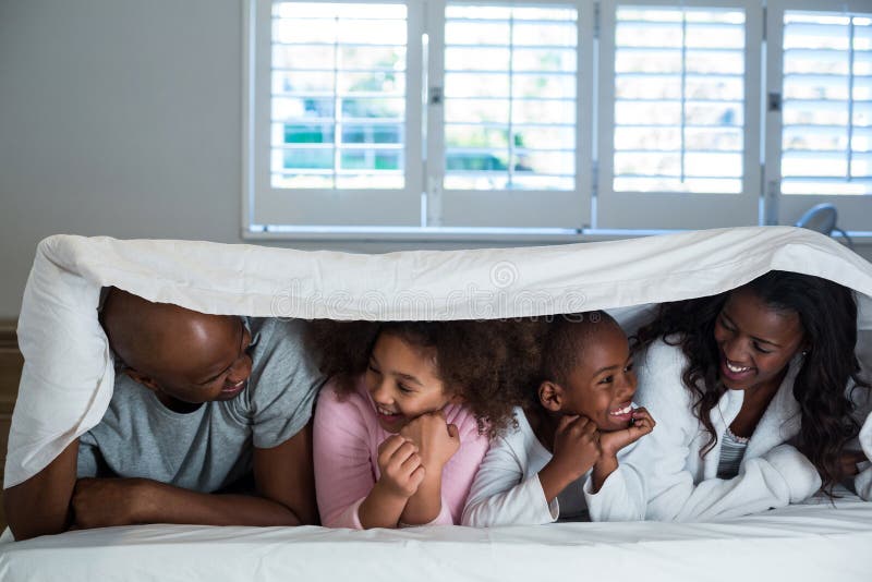 Happy Family Lying Under a Blanket on Bed Stock Photo Image of life