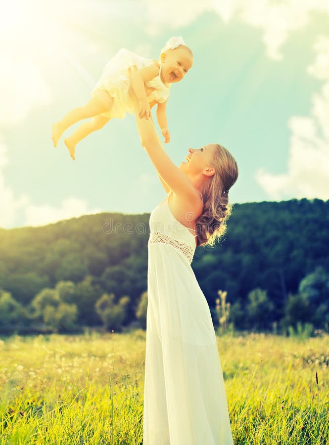 Happy family mother and baby daughter play on nature