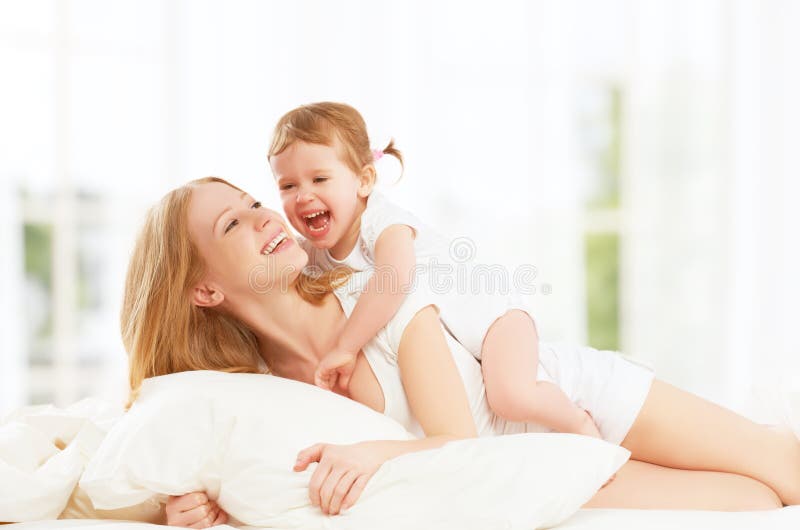 Happy family mother and baby daughter playing and laughing baby