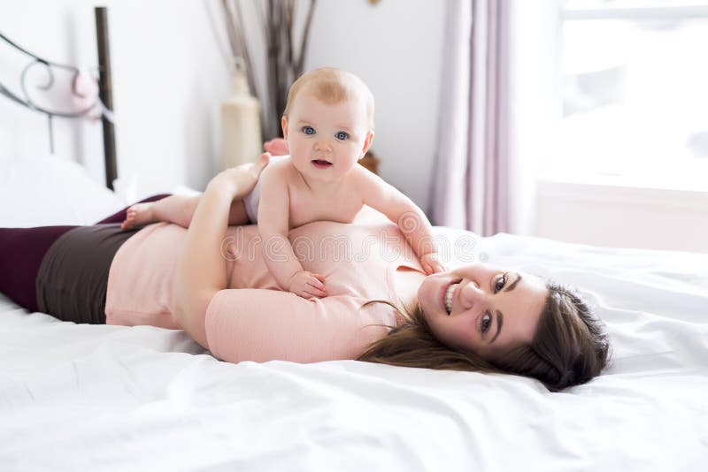 Happy family. Mother and baby playing and smiling under a blanket stock photo Happy family. Mother and baby playing and smiling under a blanket stock photo