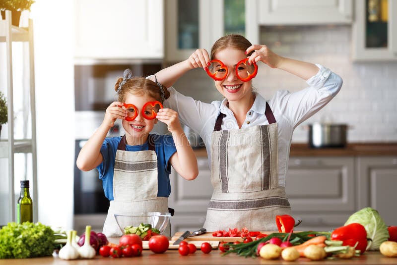 Happy family mother with child girl preparing vegetable salad