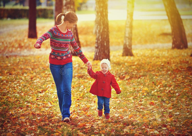 Famiglia felice, madre e figlio, figlia di correre e giocare sulla passeggiata autunnale.