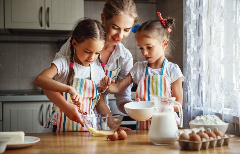 Happy family mother and children twins bake kneading dough in royalty free stock image Happy family mother and children twins bake kneading dough in royalty free stock image