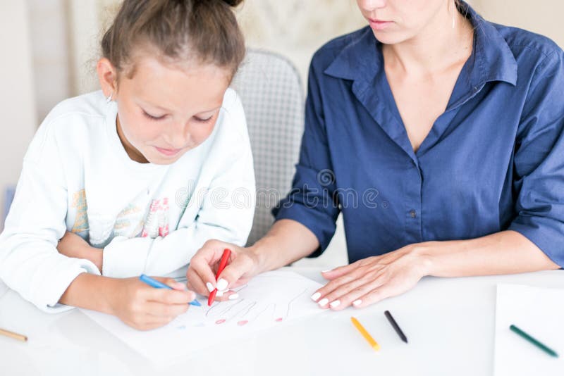 Happy family. Mother and daughter together paint and draw. Adult woman helps the child girl