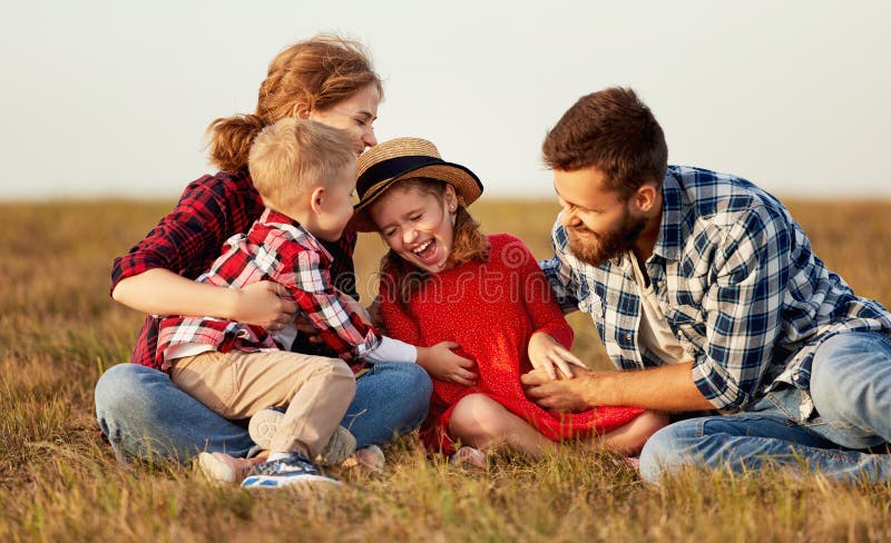 Happy family: mother, father, children son and daughter on nature on sunset