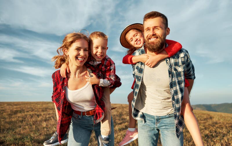 Happy family: mother, father, children son and daughter playing in nature against a blue sky