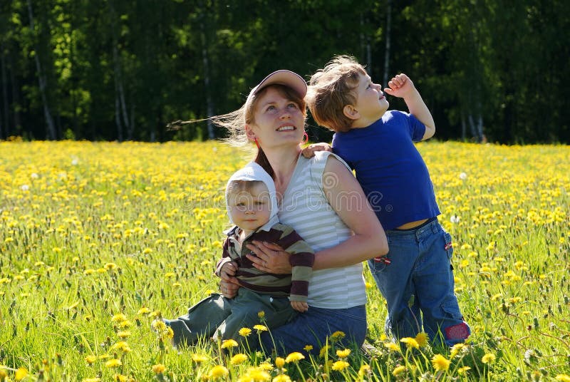 Happy family of mother and two sons in dandelion field