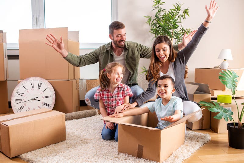 Happy family moving in their new home and having a playtime with their children royalty free stock image Happy family moving in their new home and having a playtime with their children royalty free stock image